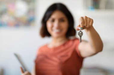 Portrait Of Smiling Young Female Real Estate Agent Holding Clipboard And Showing Home Keys In Hand, Property Manager Woman Welcoming In New House, Recommending Mortgage Programs, Selective Focus