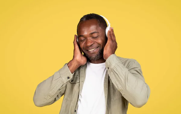 Smiling Relaxed Adult Black Guy Casual Wireless Headphones Enjoying Music — стоковое фото