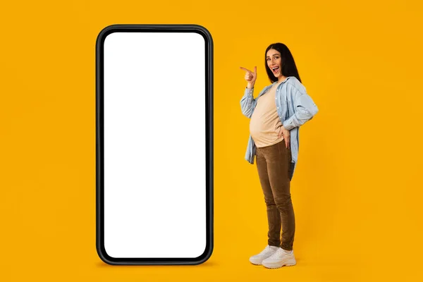 Happy Pregnant Woman Pointing Big Smartphone White Screen Standing Yellow — Photo