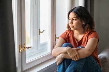 Portrait Of Pensive Young Middle Eastern Woman Sitting Near Window At Home, Thoughtful Millennial Arab Female Suffering Seasonal Depression, Thinking About Life Problems, Feeling Upset And Lonely