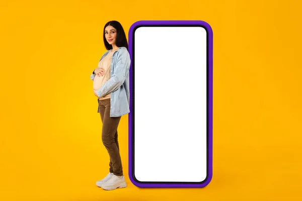 Happy Pregnant Woman Leaning Big Smartphone Blank Screen Embracing Her — Foto Stock