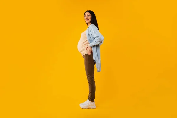 Šťastná Těhotná Žena Očekává Dítě Pózování Přes Žluté Pozadí Při — Stock fotografie