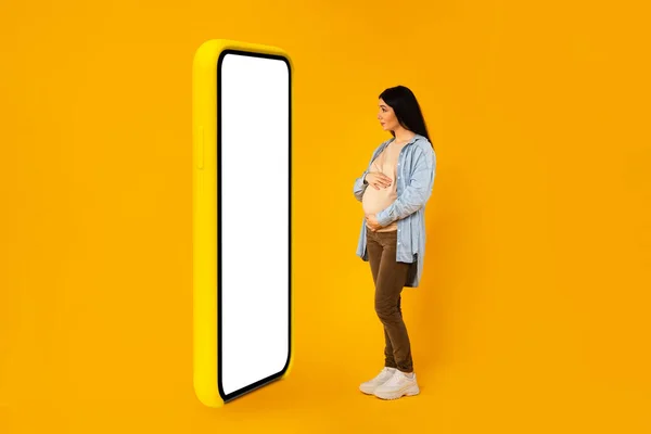 Мобільний Додаток Вагітна Жінка Стоїть Перед Величезним Порожнім Смартфоном Білим — стокове фото