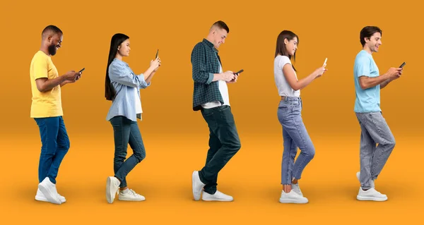 Sokszínű Többnemzetiségű Emberek Üzenetküldés Smartphone Miközben Áll Sárga Stúdió Háttér — Stock Fotó