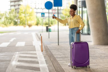 Afrika kökenli Amerikalı Turist Kadın, Modern Havalimanı 'nın yanında el hareketleriyle taksiyi durduruyor. Bayan Gezgin bir taksiye sesleniyor. Ulaşım Konsepti