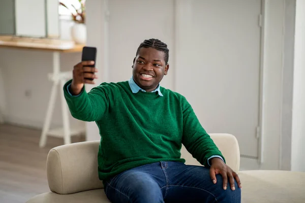 Chico Negro Alegre Haciendo Selfie Sosteniendo Smartphone Sentado Sofá Casa — Foto de Stock