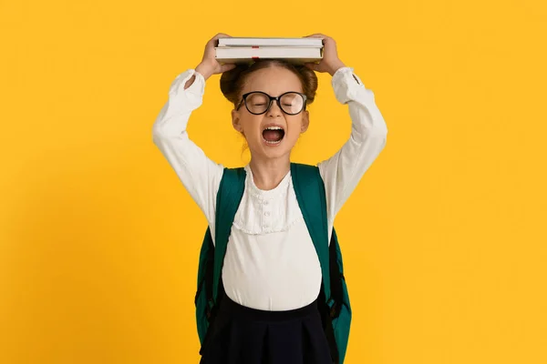 Conceito Escola Ódio Angry Little Schoolgirl Segurando Livros Cabeça Gritando — Fotografia de Stock