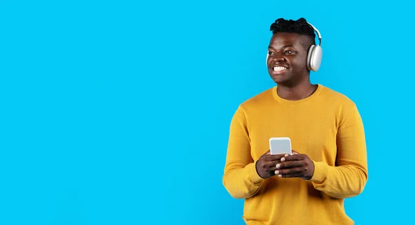 Vrolijke Zwarte Man Dragen Van Een Koptelefoon Met Een Smartphone — Stockfoto