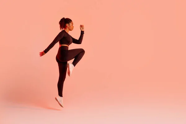 Fit Atleet Vrouw Springen Tijdens Het Sporten Perzik Neon Studio — Stockfoto