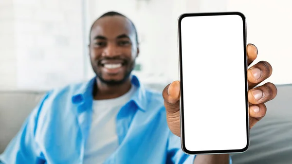Lächelnder Schwarzer Mann Zeigt Smartphone Mit Großem Weißen Bildschirm Vor — Stockfoto