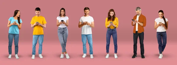 Neşeli Genç Avrupalı Kadınlar Erkekler Akıllı Telefonlarıyla Yazıyorlar Pembe Arka — Stok fotoğraf