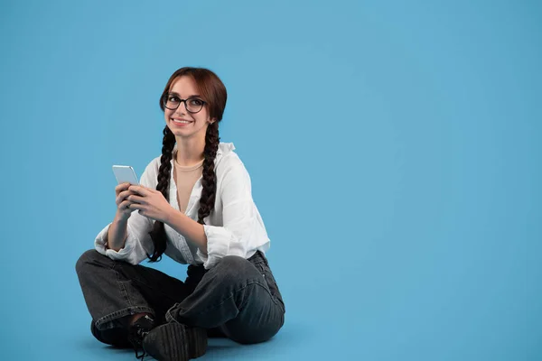 Šťastný Evropský Dospívající Studentka Copánky Brýlích Sedí Podlaze Píše Telefonu — Stock fotografie