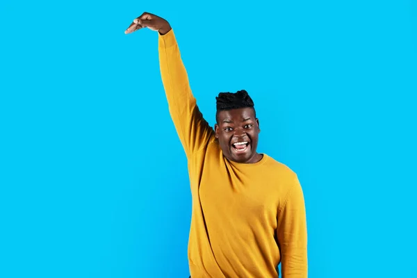 Happy Young Black Man Measuring Hight Invisible Object Hand While — Φωτογραφία Αρχείου