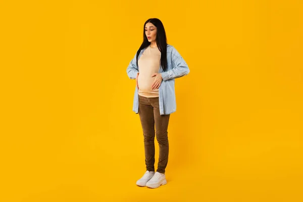 全身上下全身上下拍摄孕妇腹部疼痛 触摸腹部和呼吸 站立在黄色工作室背景 复制空间 — 图库照片