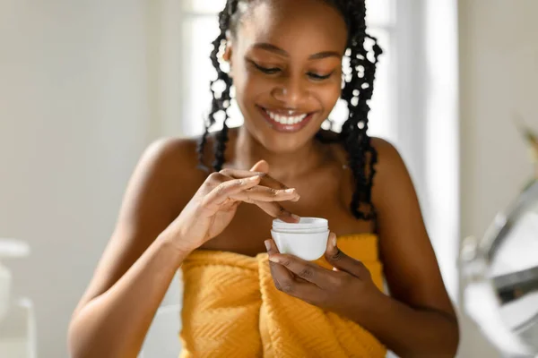 日用护肤松节油 快乐的黑人女人拿着奶油罐 涂上润肤霜 选择性地专注于双手 照顾老化肌肤的女士 — 图库照片