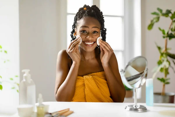Yatak Odasında Aynanın Önünde Oturan Mutlu Siyah Kadın Makyajını Siliyor — Stok fotoğraf