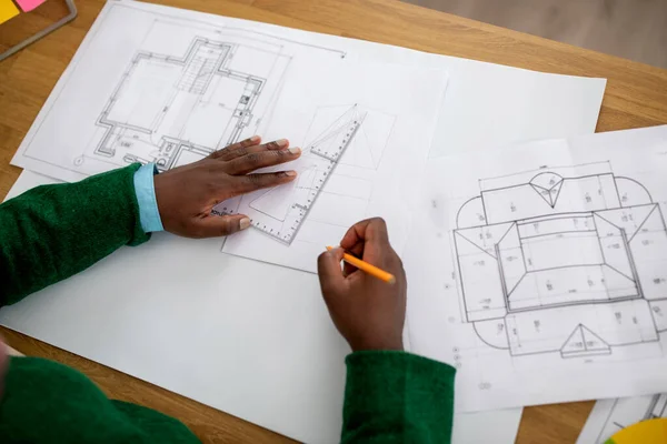 无法辨认的黑人男性建筑师创作工程图纸 持有在现代办公室工作的铅笔和尺子的平面图或方案 完成设计师手工操作 以上视图 — 图库照片