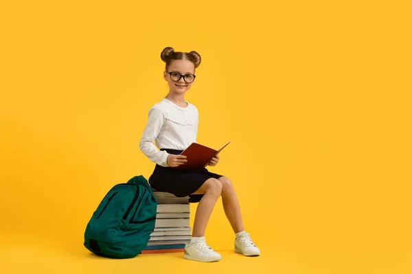 Roztomilá Malá Školačka Brýlích Sedí Hromadě Knih Přes Žluté Pozadí — Stock fotografie