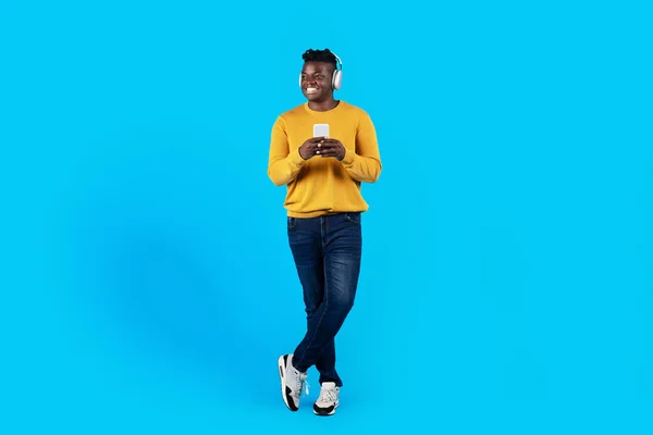 Glimlachende Zwarte Man Draadloze Koptelefoon Met Een Smartphone Zoek Weg — Stockfoto