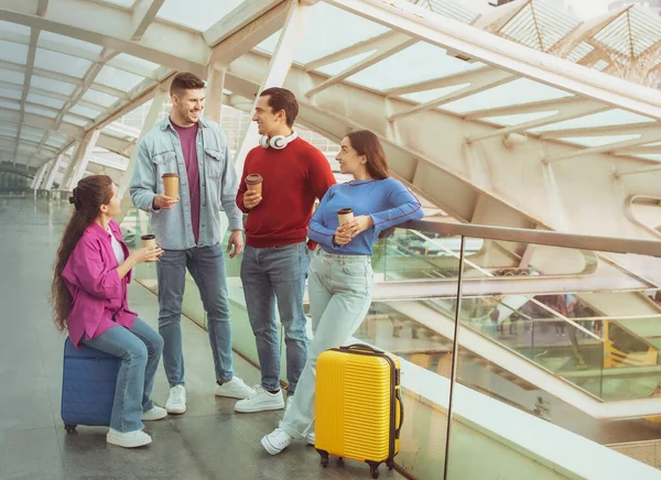 友人との休暇 現代の空港の屋内で旅行スーツケースと一緒にフライトとコーヒーを飲みながら待っている4人の若者 交通と観光の概念 — ストック写真