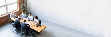 Takım çalışması konsepti. Çeşitli meslektaşlar Modern Ofis 'te aynı masada birlikte çalışıyor. Kasıtlı Ekip brifing veriyor. Yüksek Açı Çekimi, Kopyalama Alanı ve Kolajı olan Panorama