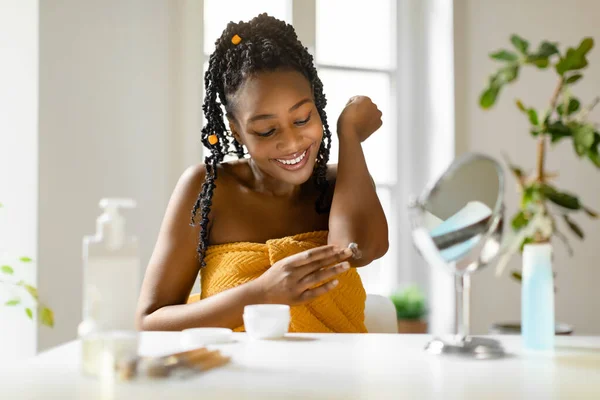 Mujer Afroamericana Joven Envuelta Toalla Aplicando Crema Calmante Codo Hidratando —  Fotos de Stock