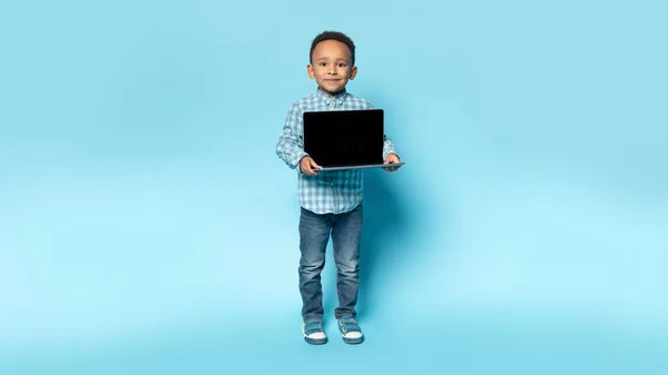 Entzückender Schwarzer Junge Zeigt Laptop Mit Leerem Bildschirm Stehend Auf — Stockfoto