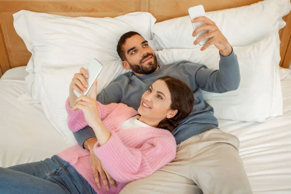 Evdeki Modern Yatak Odasındaki Yatakta Uzanan Akıllı Telefonları Mesajlaşmak Interneti — Stok fotoğraf