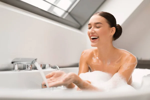 Happy Woman Taking Bath Foam Touching Running Hot Water Tap — Stock Photo, Image