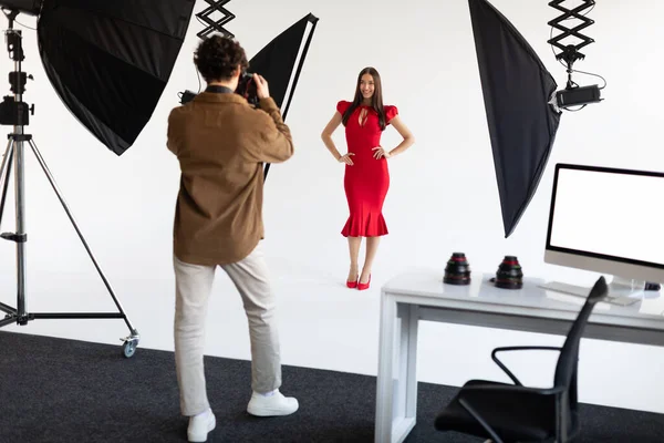镜头后面的场景 女模特为摄影师摆姿势 男人用专业相机拍照 工作室里的时尚杂志摄影 — 图库照片