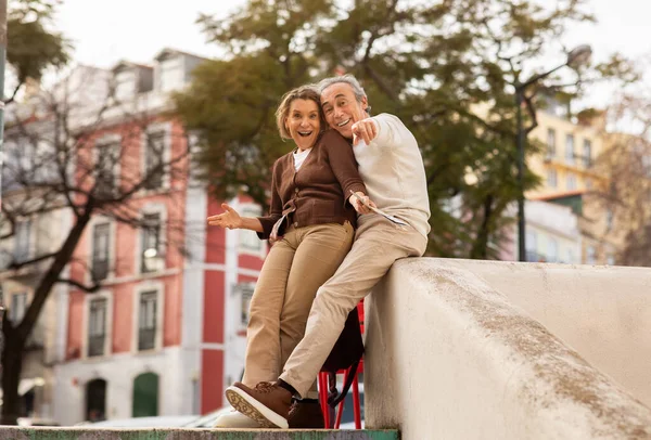 Joyful Senior Couple Pointing Finger Camera Sitting Outdoors Traveling Together — Stock Photo, Image
