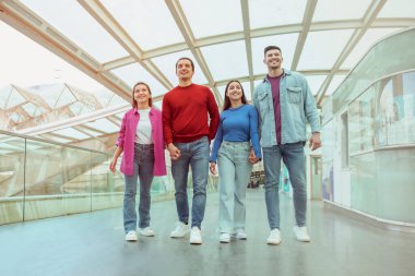 Turizm. Modern havalimanında el ele tutuşan iki neşeli çift birlikte tatile çıkıyorlar. Dört Genç Turistin Tam Uzunluk Çekimi. Arkadaşlarla Seyahat Konsepti