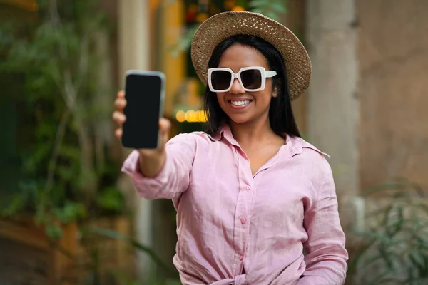 Alegre Millennial Mujer Afroamericana Turista Sombrero Gafas Sol Muestra Smartphone — Foto de Stock