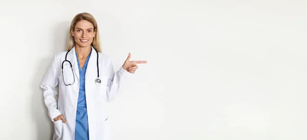 Ιατρική Προσφορά Χαμογελώντας Γιατρός Κυρία Στολή Δείχνοντας Πέρα Από Χώρο — Φωτογραφία Αρχείου