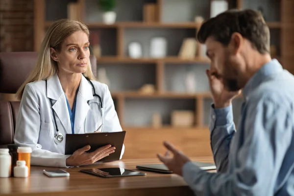 Ärztin Hört Männliche Patientin Bei Besprechung Büro Über Gesundheitsprobleme Aufmerksame — Stockfoto