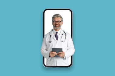 Telemedicine, appointment with doc online. Smiling friendly handsome grey-haired middle aged doctor with digital pad and stethoscope at huge smartphone screen, isolated on blue background, collage clipart