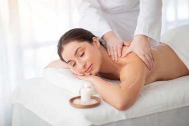Spa masajı. Güzeller güzeli Hintli kadın, profesyonel masör tarafından tedavi ediliyor, Hindu kadın, güzellik prosedürlerinden keyif alıyor, kapalı gözlerle masaya uzanıyor,