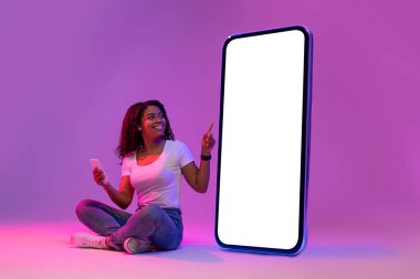 Şuna bak. Neon Işığında Büyük Boş Akıllı Telefonu Gösteren Mutlu Siyah Kadın, Elinde Cep Telefonu ile Gülümseyen Afro-Amerikan Kadın Yeni Mobil Uygulama, Kolaj, Model