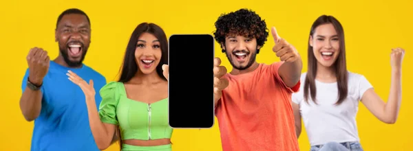 놀랍게 사람들 손가락을 화면을 스마트폰을 승리의 손짓을 노란색 스튜디오 배경에 — 스톡 사진