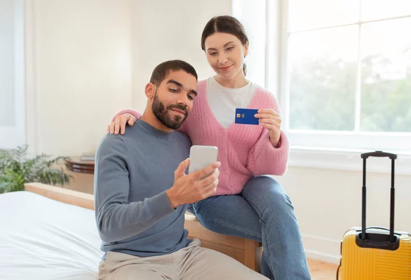 Tourists Couple Using Smartphone Credit Card Booking Hotel Room Sitting — Stock Photo, Image