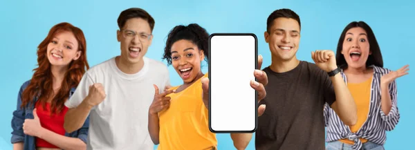 驚きの幸せな千年のアジア人 黒と白人の人々は 空白の画面でスマートフォンで指を指す 勝利と成功ジェスチャーを作る ウェブサイトをお勧めします 青の背景にアプリ パノラマ — ストック写真