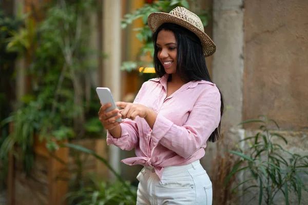 Glad Millennial Africana Americana Turista Sombrero Escribiendo Teléfono Inteligente Buscando —  Fotos de Stock