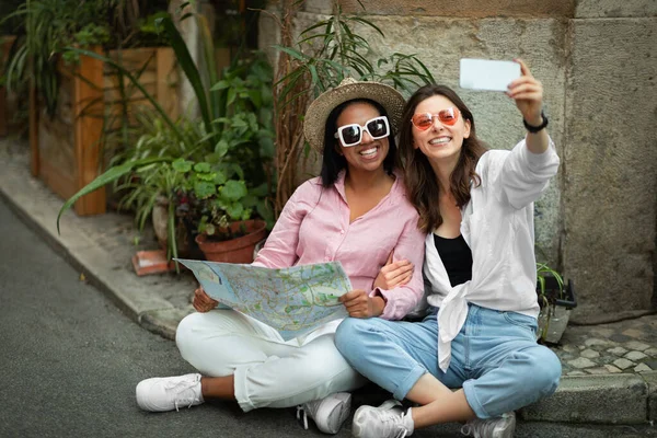 Alegre Millennial Multirracial Turistas Mujeres Casual Sombrero Sentado Suelo Mirando — Foto de Stock
