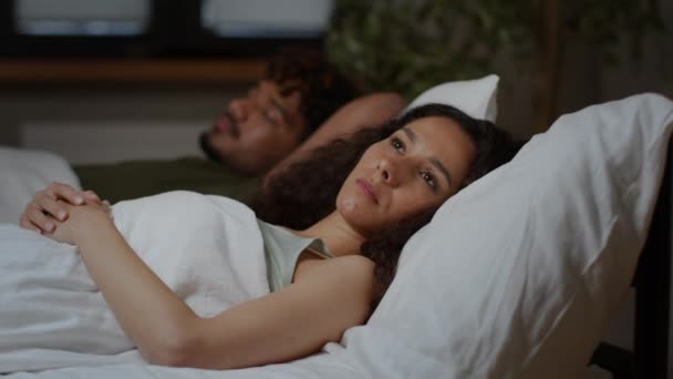 失眠的概念 年轻的中东女人患有睡眠障碍 睁着眼躺在熟睡的丈夫身边 想着自己的生活 跟踪镜头 自由自在的空间 — 图库视频影像