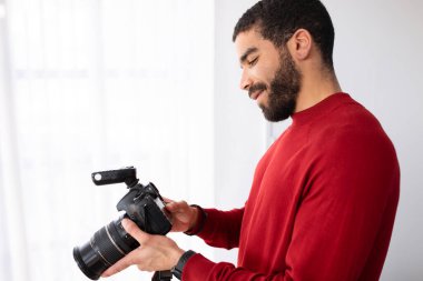 Profesyonel erkek fotoğrafçı mutlu, sakallı, orta doğu sakallı, fotoğraf stüdyosunda dijital fotoğraf makinesi olan, fotoğrafçı, fotokopi odası. İş ve Meslek kavramı