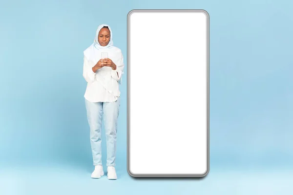 Wanita Muslim Hitam Menggunakan Ponsel Saat Berdiri Dekat Layar Smartphone — Stok Foto