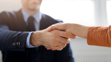 İş ortaklığı. Erkek ve kadın girişimciler el sıkışıyor, iş birliği anlaşmasını kutluyorlar, kesiliyor, kapatılıyor. İş adamı ve iş kadını başarılı bir anlaşmadan sonra tokalaşıyorlar.