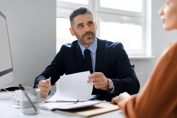 Searching for job concept. Human resources male manager speaking to employment applicant on work interview, sitting at office. Personnel manager talking to female vacancy candidate