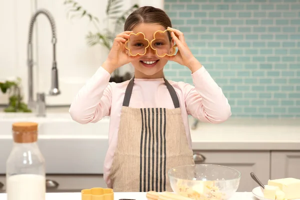 Cheerful European Little Girl Apron Makes Cookies Puts Cookie Cutters — Stock Photo, Image