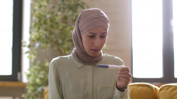 Несподівана Вагітність Молода Хвилююча Мусульманка Традиційному Хіджабі Сидить Вдома Тестом — стокове відео